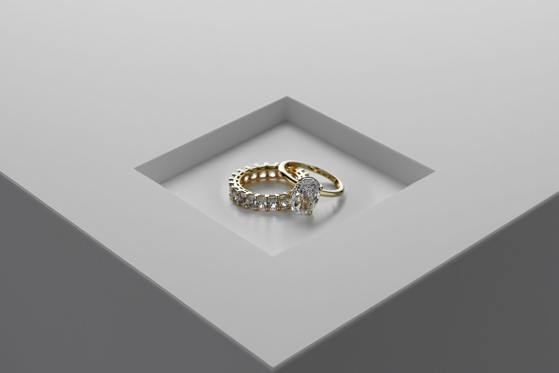 A close-up of exquisite gold and diamond rings set on a minimalist surface. — Gemstone Jewelry - Can They Bring Luck to You?